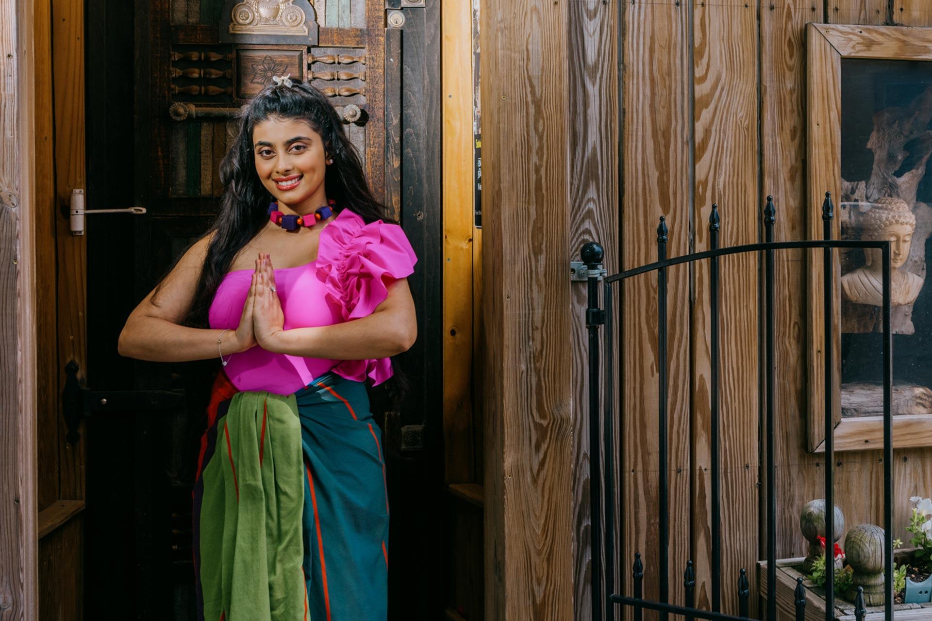 a woman standing in front of a wooden building.