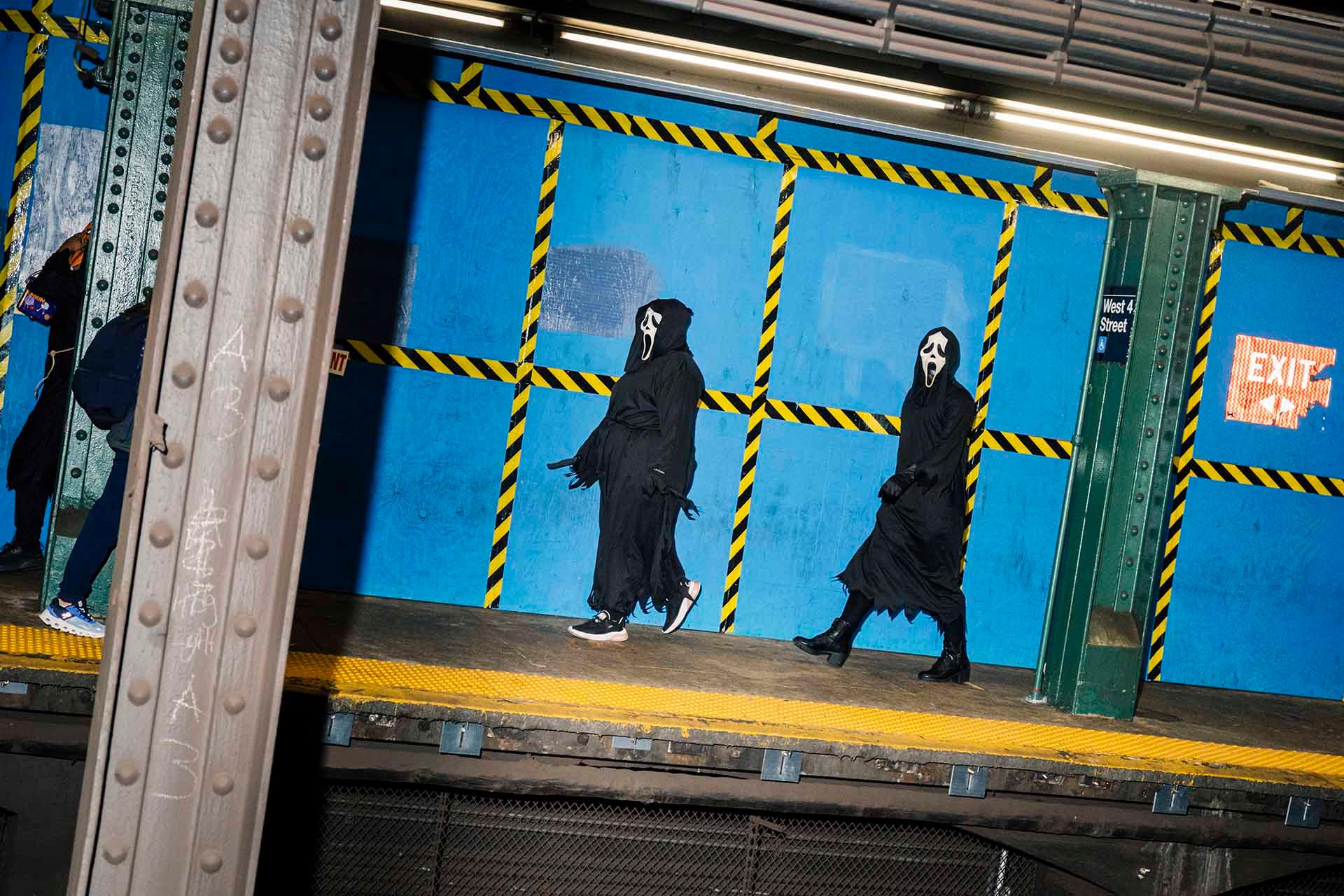 Two people dressed up as Ghostface, captured from across the platform.